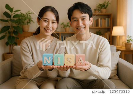 リビングでNISAを学ぶ若いカップルのライフスタイル リビングでNISAを学ぶ若いカップルのライフスタイル 125473519