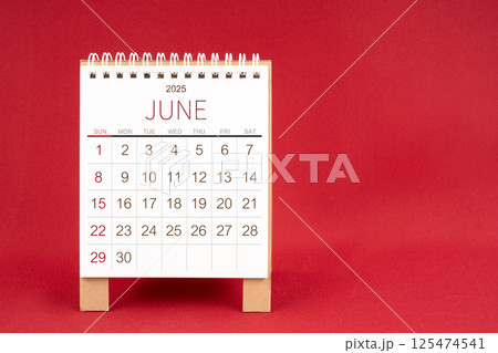 Blank desk calendar for June 2025 on red background. 125474541