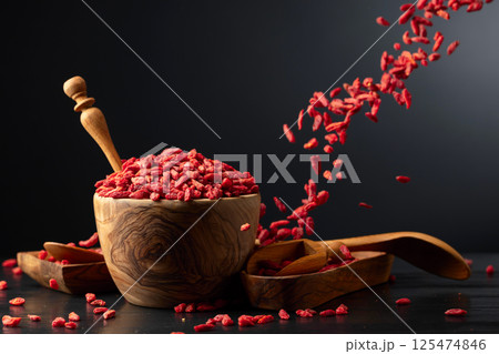 Dried goji berries in wooden bowl on a black background. Dried goji berries in wooden bowl on a black background. 125474846