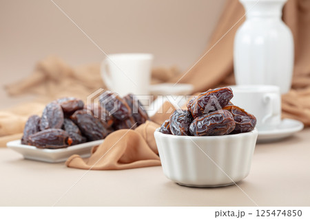 Dates in white dish on a beige background. Dates in white dish on a beige background. 125474850