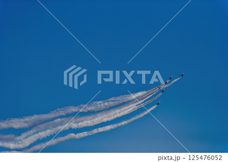 飛行機雲を引きながら飛行する航空機 　ブルーインパルス　青空　航空自衛隊　戦闘機　飛行機　入間基地 125476052