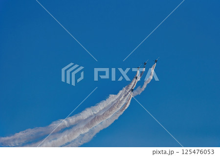 飛行機雲を引きながら飛行する航空機 　ブルーインパルス　青空　航空自衛隊　戦闘機　飛行機　入間基地 125476053
