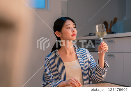 家でワインを楽しむ一人暮らしの女性 家でワインを楽しむ一人暮らしの女性 125476605