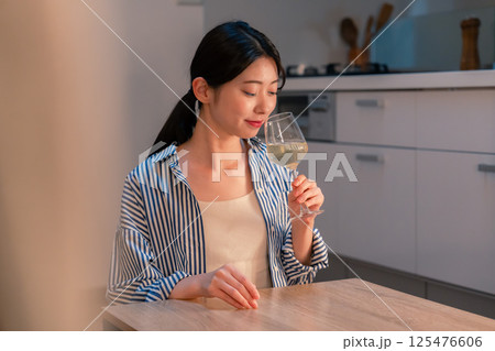 家でワインを楽しむ一人暮らしの女性 家でワインを楽しむ一人暮らしの女性 125476606