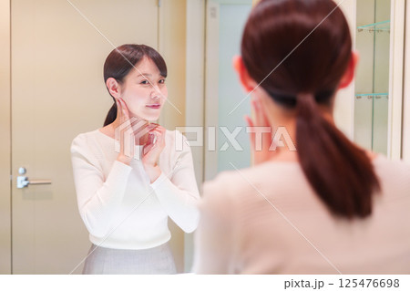 お出かけ前に身だしなみを整えるミドルシニアの女性 125476698