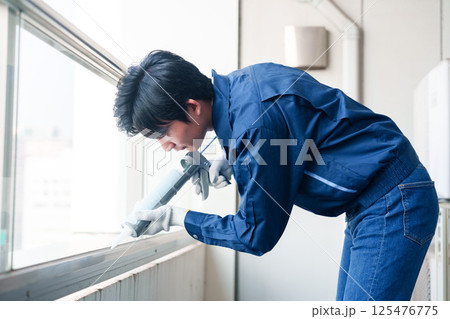 外装工事でコーキング材を塗る作業員の男性 外装工事でコーキング材を塗る作業員の男性 125476775