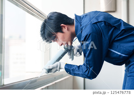 外装工事でコーキング材を塗る作業員の男性 外装工事でコーキング材を塗る作業員の男性 125476778
