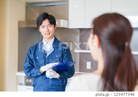 マンションを戸別訪問して点検をする業者の男性 125477346