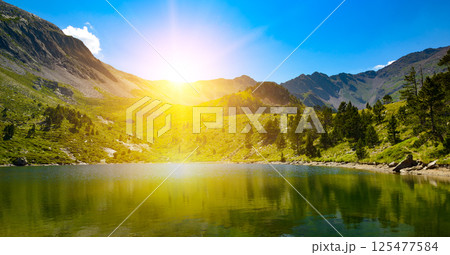 Sunrise over a picturesque small lake high in mountains against sky. 125477584