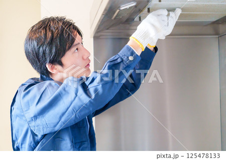 レンジフードのクリーニングをする男性の作業員 125478133