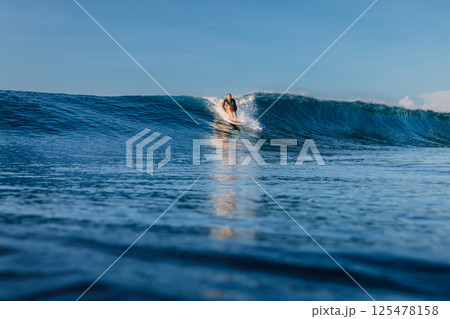 Woman surfer on perfect wave, surfing in ocean. Woman surfer on perfect wave, surfing in ocean. 125478158