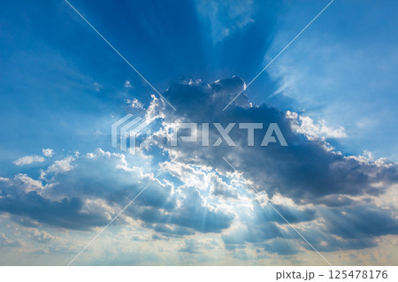 Dramatic cloudy sky clouds with real sun beams 125478176