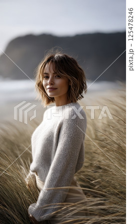 Portrait of a Young Woman in Beige Sweater Amidst Beach Grass Portrait of a Young Woman in Beige Sweater Amidst Beach Grass 125478246