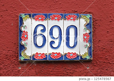 House number on red facade 125478567