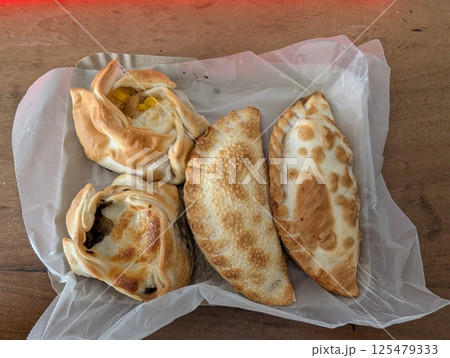 Empanada is a traditional Argentine dish. Several empanadas with different fillings in a delivery box Empanada is a traditional Argentine dish. Several empanadas with different fillings in a delivery box 125479333