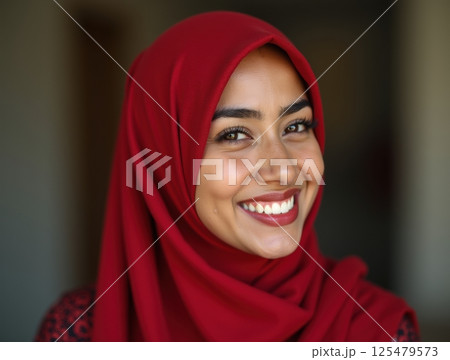 Young woman in red hijab smiles subtly. Young woman in red hijab smiles subtly. 125479573