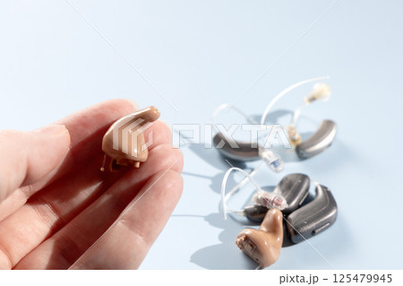 Female hand holding modern hearing aid 125479945