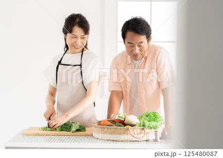 キッチンで料理をする50代夫婦 125480087