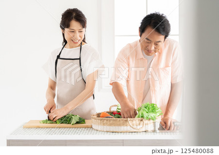 キッチンで料理をする50代夫婦 125480088