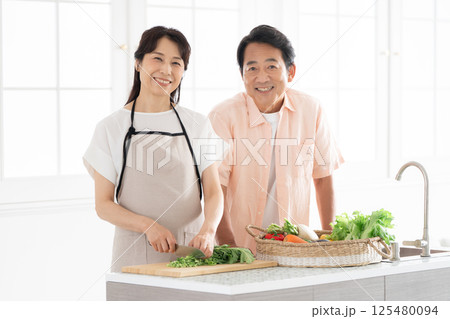 キッチンで料理をする50代夫婦 125480094