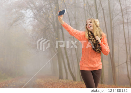 Happy fashion woman in park taking selfie photo. Happy fashion woman in park taking selfie photo. 125480182