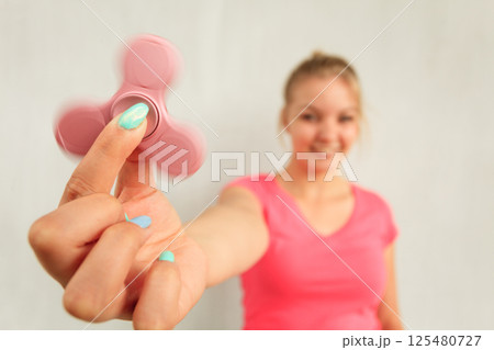 Woman playing fidget spinner 125480727