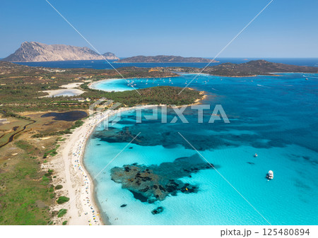 Aerial view of white sandy beach with umbrellas, luxury yachts 125480894