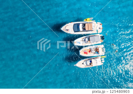 Aerial view of luxury yacht and boat in blue sea in summer Aerial view of luxury yacht and boat in blue sea in summer 125480903