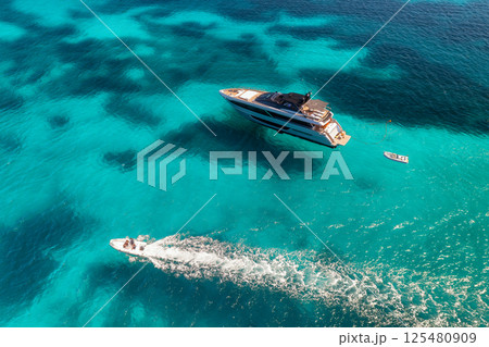Aerial view of luxury yacht and boat in blue sea in summer Aerial view of luxury yacht and boat in blue sea in summer 125480909