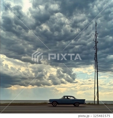 Cinematic portrait of a stormy sky with a car driving along the shore at twilight 125481575