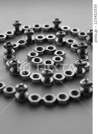 Grayscale Image Of Mechanical Pattern Part Made With Same Metal Nuts And Screwed Cross Head Bolts. Vertical Stock Photo For Mechanism Illustration  125482039