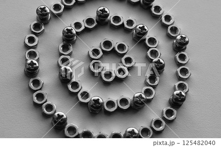 Pattern of perfect rings made of nuts with bolts screwed into them monochrome stock photo for mechanical backgrounds Pattern of perfect rings made of nuts with bolts screwed into them monochrome stock photo for mechanical backgrounds 125482040
