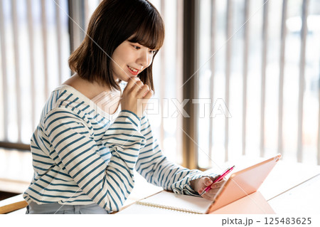 タブレットを使って勉強する若い女性 125483625