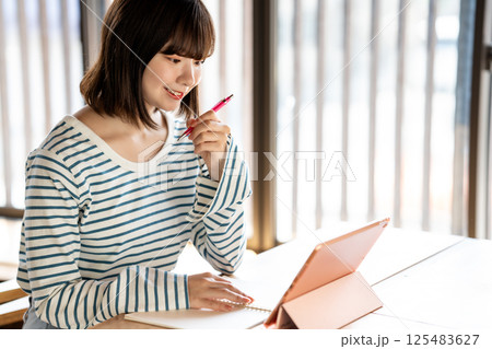 タブレットを使って勉強する若い女性 125483627