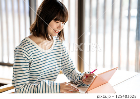 タブレットを使って勉強する若い女性 タブレットを使って勉強する若い女性 125483628