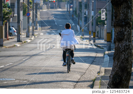 休日の朝、自転車に乗りテニスに行く女性 神戸岡本で撮影 休日の朝、自転車に乗りテニスに行く女性 神戸岡本で撮影 125483724