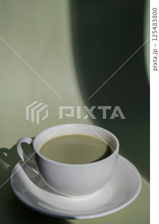 Sweet yellow macaron dessert Cup of green plant based matcha tea latte in cozy morning atmosphere. Creative holiday romantic date idea. Herbal prebiotic fiber superfood beverage antioxidant-rich Sweet yellow macaron dessert Cup of green plant based matcha tea latte in cozy morning atmosphere. Creative holiday romantic date idea. Herbal prebiotic fiber superfood beverage antioxidant-rich 125483800