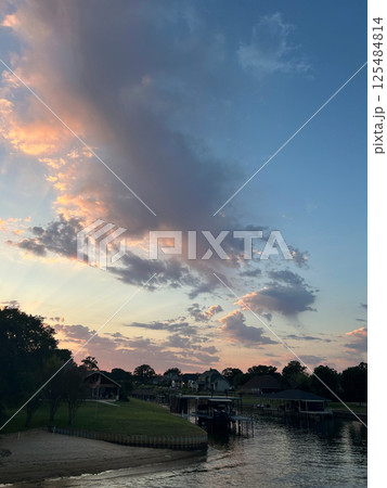 Colorful sunset clouds over Cedar Creek Reservoir waterfront in Texas 125484814