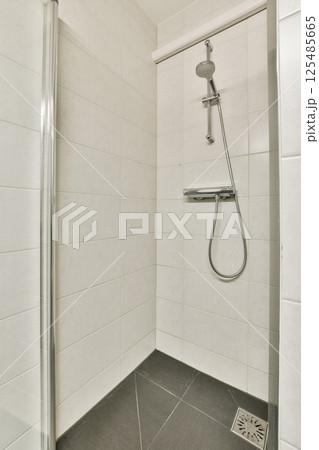 A sleek and contemporary shower area showcasing clean lines and neutral tones, designed for functionality and simplicity in a modern bathroom. 125485665