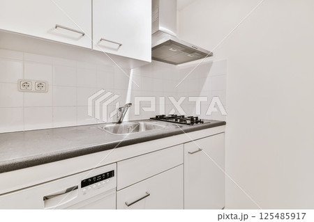 a kitchen with white cabinets and black counter tops on the counters in front of the dishwasher there is an appliance a kitchen with white cabinets and black counter tops on the counters in front of the dishwasher there is an appliance 125485917