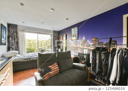 A stylish living area featuring a captivating cityscape wall art, modern furniture, and a bright window, creating a welcoming atmosphere. 125486010