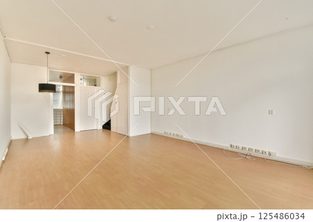 A spacious, minimalist interior showcasing a modern living area with clean lines, wooden flooring, and neutral colors, perfect for contemporary decor. A spacious, minimalist interior showcasing a modern living area with clean lines, wooden flooring, and neutral colors, perfect for contemporary decor. 125486034