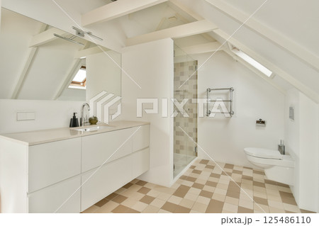 A stylish modern bathroom featuring a spacious shower, vanity with mirror, and chic tile flooring. The minimalist design emphasizes functionality and aesthetics. A stylish modern bathroom featuring a spacious shower, vanity with mirror, and chic tile flooring. The minimalist design emphasizes functionality and aesthetics. 125486110