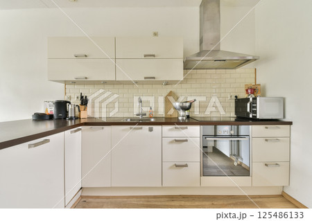 A well-designed modern kitchen featuring contemporary cabinetry, appliances, and an organized layout for efficient cooking and dining. 125486133