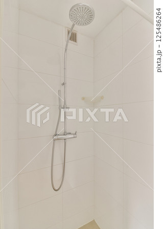 A sleek and contemporary shower setup featuring a modern showerhead and minimalistic design elements, ideal for a luxurious bathing experience. A sleek and contemporary shower setup featuring a modern showerhead and minimalistic design elements, ideal for a luxurious bathing experience. 125486264