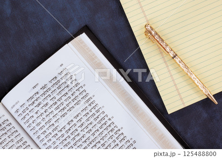 24 April 2025 Jerusalem Israel Ancient Hebrew Tanakh book lie open on table, with golden pen, notepad ready symbolizing Messianic Jewish Congregation "Hebrew Tanakh prayer holy book" 125488800