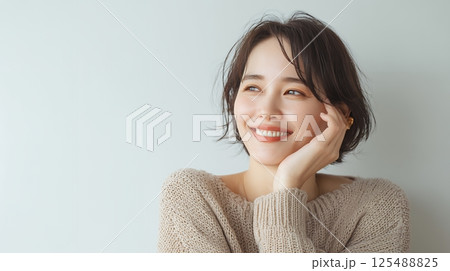 部屋で頬杖をつく女性 125488825