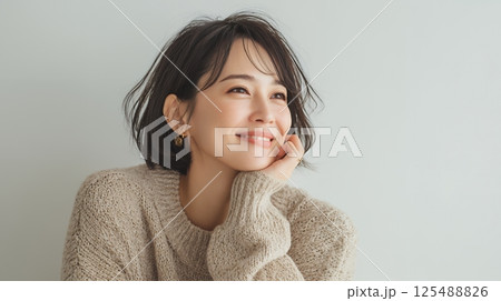 部屋で頬杖をつく女性 125488826
