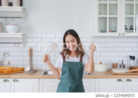 Young Asian woman dancing in the kitchen 125489055