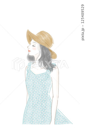 風を感じている麦わら帽子をかぶった夏服の女性 125489529
